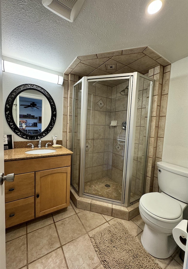 bathroom featuring toilet, tile patterned flooring, vanity, and walk in shower