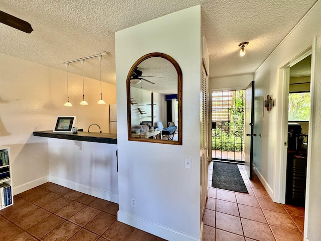 kitchen featuring track lighting, white refrigerator, tile patterned flooring, ceiling fan, and decorative light fixtures