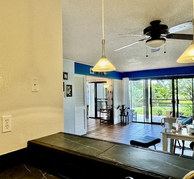 interior space featuring ceiling fan and a textured ceiling