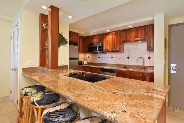 4327 Lower Honoapiilani Rd Unit 1203, Lahaina, HI 96761 - kitchen with stainless steel appliances, a breakfast bar area, light tile patterned floors, a sink, and a peninsula