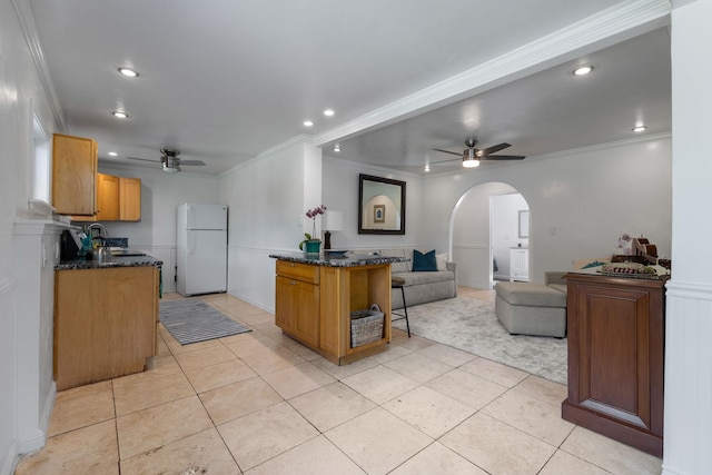 kitchen with light tile patterned floors, white refrigerator, ceiling fan, and ornamental molding