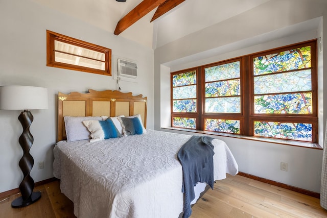 bedroom featuring beam ceiling, light hardwood / wood-style floors, a wall unit AC, and ceiling fan