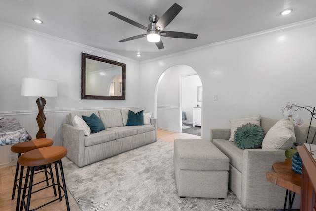 living room with ceiling fan and ornamental molding