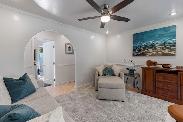 tiled living room featuring ceiling fan and ornamental molding