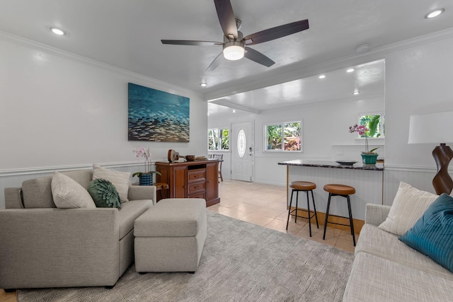 living room with ceiling fan, light tile patterned floors, and crown molding