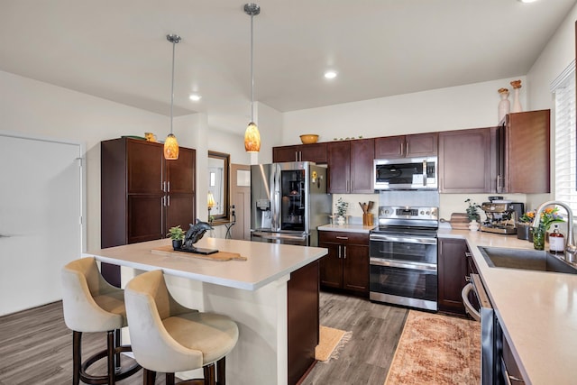 235 Kilioopu St, Wailuku, HI 96793 - kitchen with stainless steel appliances, a sink, a kitchen breakfast bar, light countertops, and light wood finished floors
