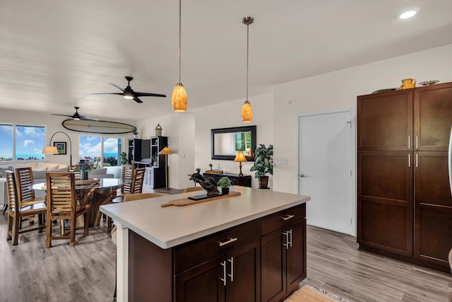 235 Kilioopu St, Wailuku, HI 96793 - kitchen with light wood-style flooring, light countertops, ceiling fan, decorative light fixtures, and dark brown cabinetry