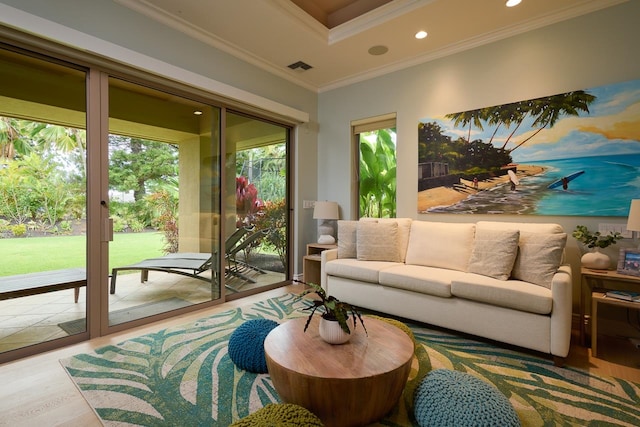 living room featuring crown molding, a healthy amount of sunlight, and wood-type flooring