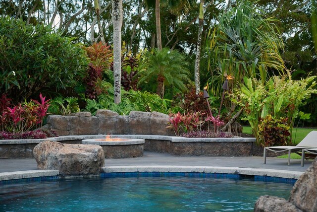 outdoor pool featuring a patio and a fire pit