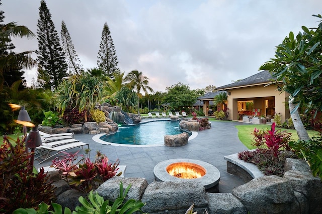 view of swimming pool featuring an outdoor fire pit, pool water feature, and a patio area