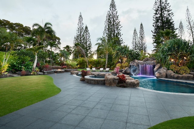 exterior space featuring an in ground hot tub and pool water feature