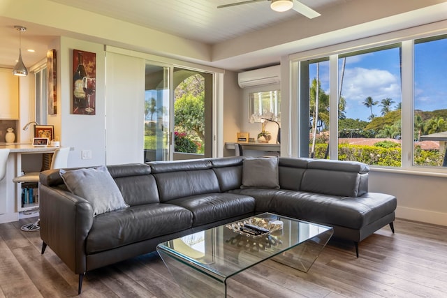 living room with hardwood / wood-style flooring, an AC wall unit, and ceiling fan