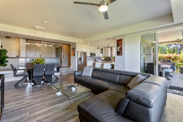 living room featuring wood-type flooring and ceiling fan