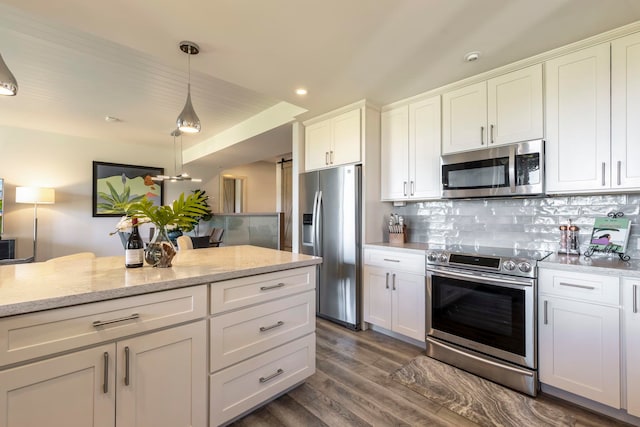 kitchen featuring hanging light fixtures, white cabinets, dark wood-type flooring, backsplash, and appliances with stainless steel finishes