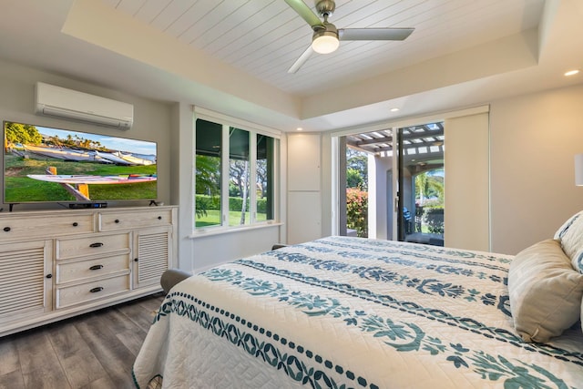 bedroom with ceiling fan, access to exterior, dark wood-type flooring, a wall unit AC, and a raised ceiling