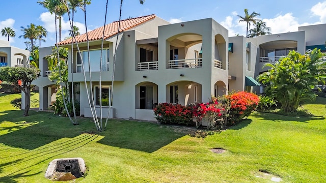 view of front of house featuring a front yard and a balcony