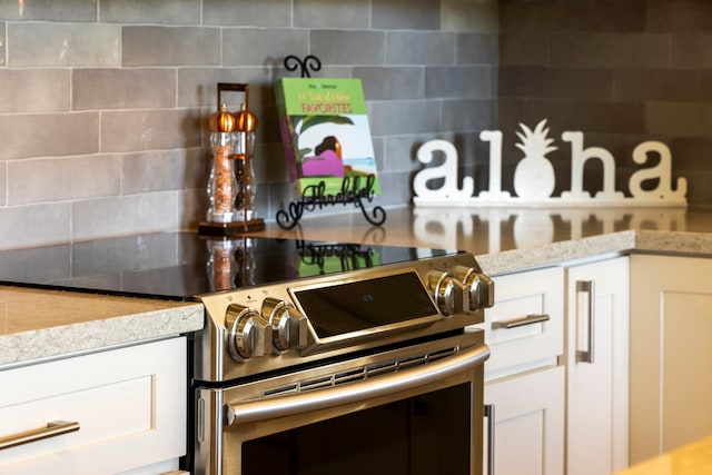 kitchen featuring white cabinetry and stainless steel electric stove