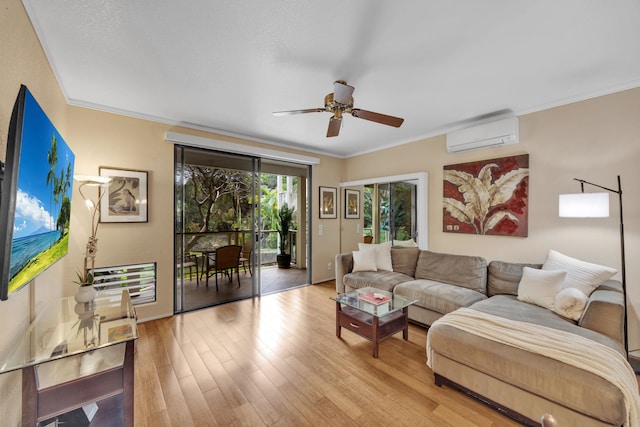 living room with ornamental molding, a wall mounted air conditioner, and light wood-style flooring