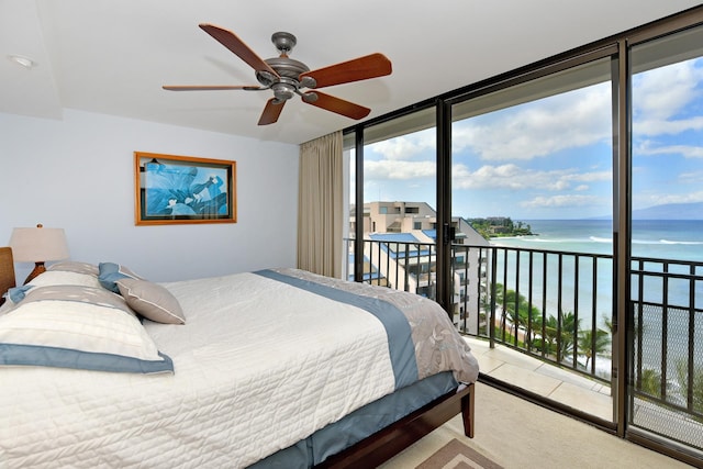 bedroom featuring ceiling fan, a water view, access to exterior, and multiple windows