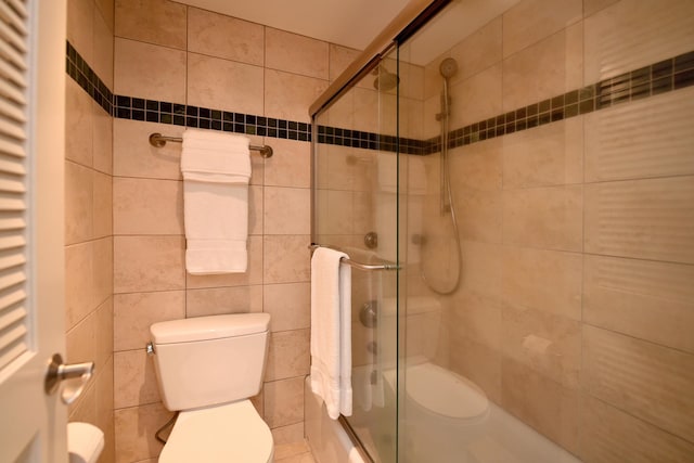 bathroom featuring tile walls and toilet