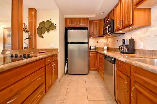 kitchen featuring backsplash, appliances with stainless steel finishes, light tile flooring, and light stone countertops