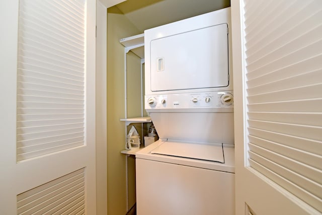 washroom featuring stacked washer / drying machine