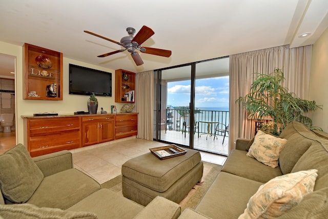 living room with light tile flooring, ceiling fan, a healthy amount of sunlight, and expansive windows