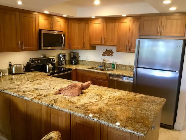 kitchen with light tile patterned flooring, sink, kitchen peninsula, stainless steel appliances, and light stone countertops