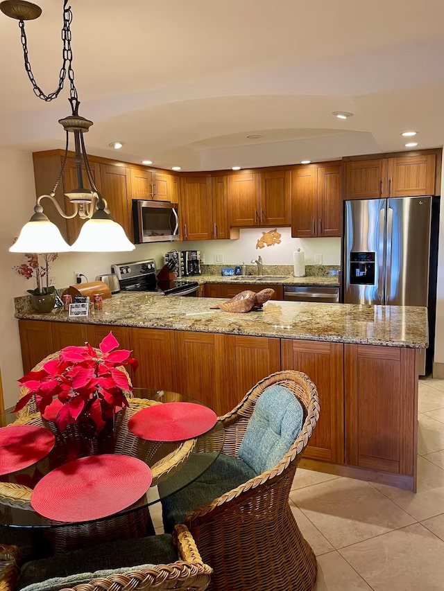 kitchen with stainless steel appliances, pendant lighting, light tile patterned floors, and kitchen peninsula