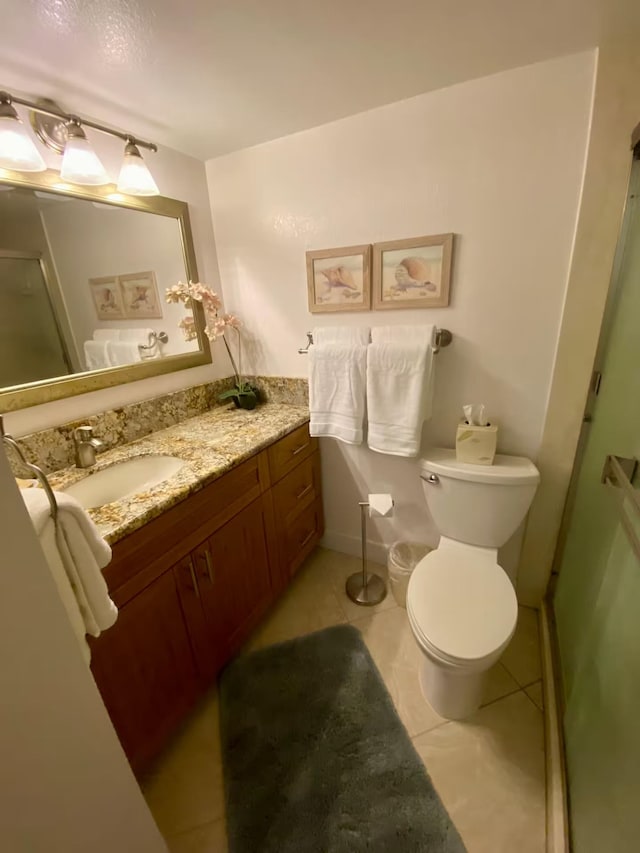 bathroom featuring vanity, toilet, tile patterned floors, and walk in shower