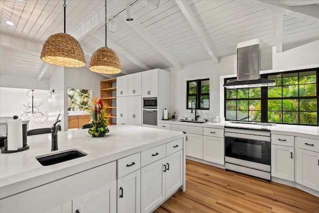 kitchen with island range hood, a sink, appliances with stainless steel finishes, light wood-style flooring, and recessed lighting