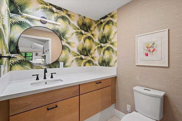 bathroom featuring wallpapered walls, vanity, and toilet