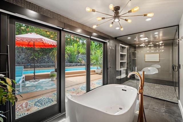 full bath with plenty of natural light, a chandelier, a shower stall, a freestanding tub, and recessed lighting