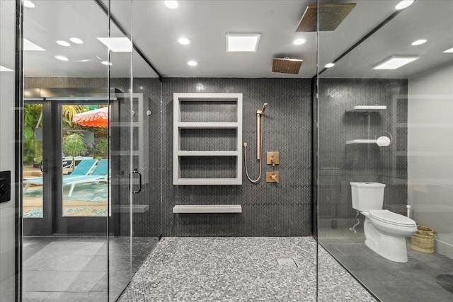 bathroom featuring a tile shower, toilet, and recessed lighting