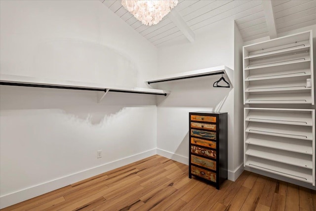 spacious closet with wood-type flooring and a chandelier