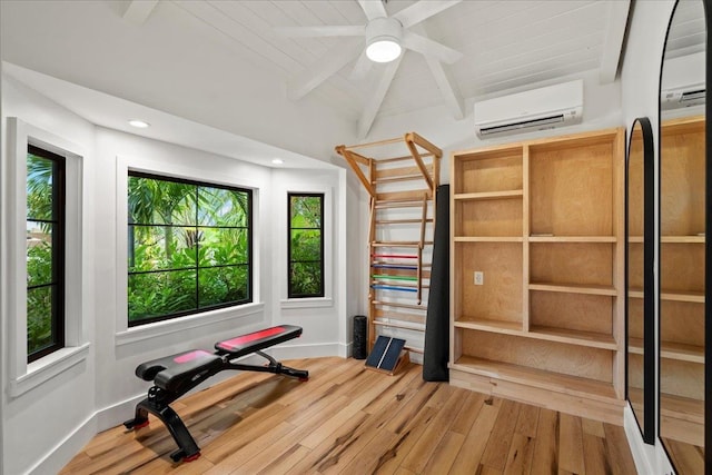 exercise room featuring a wall mounted AC, lofted ceiling, wood finished floors, baseboards, and ceiling fan