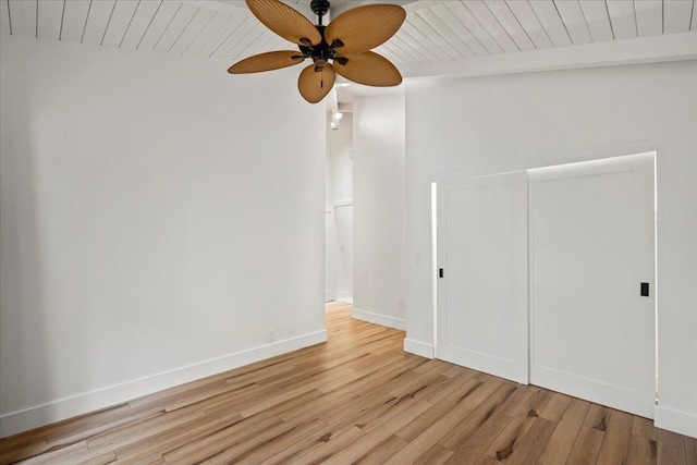 empty room with ceiling fan, light wood-style floors, wood ceiling, beam ceiling, and baseboards