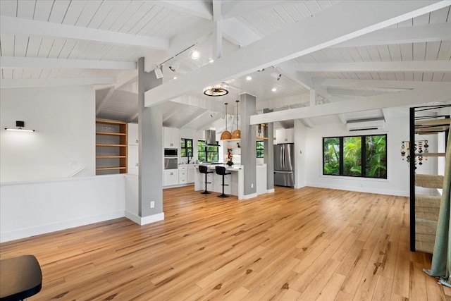 unfurnished living room featuring an AC wall unit, light wood finished floors, baseboards, wood ceiling, and track lighting