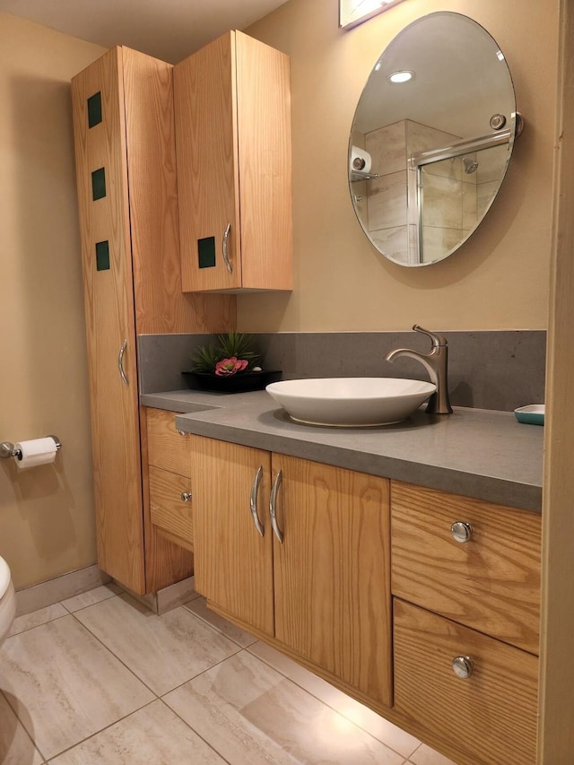 bathroom featuring toilet, tile flooring, and vanity