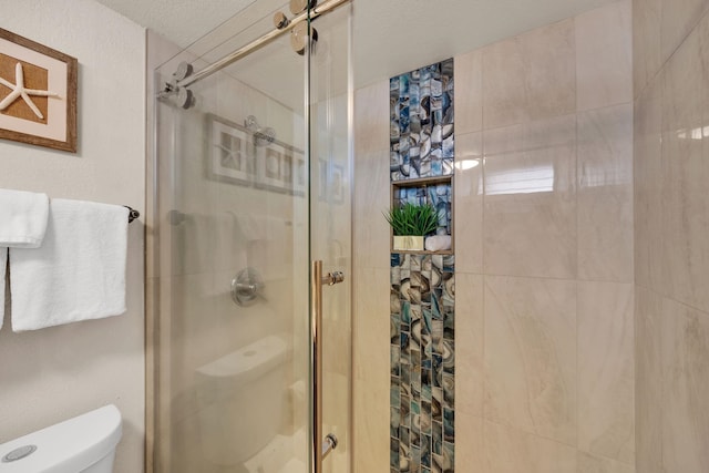 bathroom featuring a shower stall and toilet