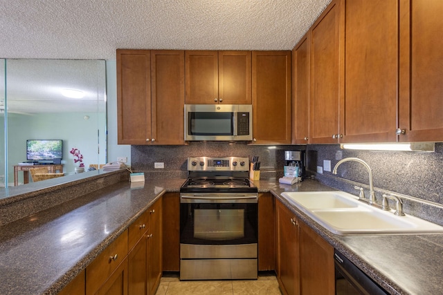 kitchen with backsplash, light tile patterned flooring, sink, and appliances with stainless steel finishes