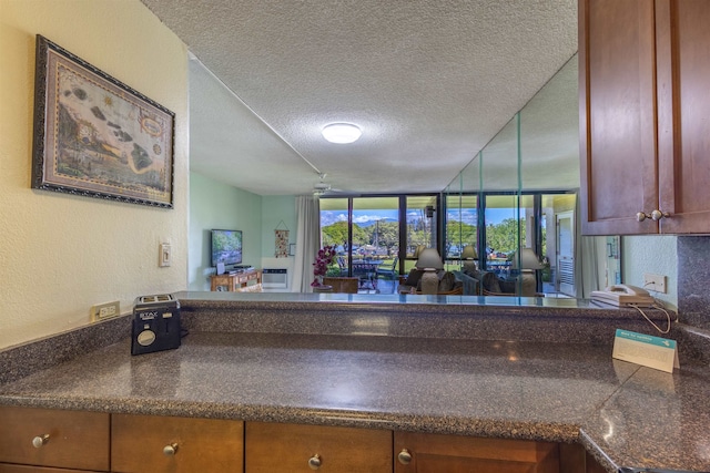 kitchen featuring floor to ceiling windows, ceiling fan, and a textured ceiling