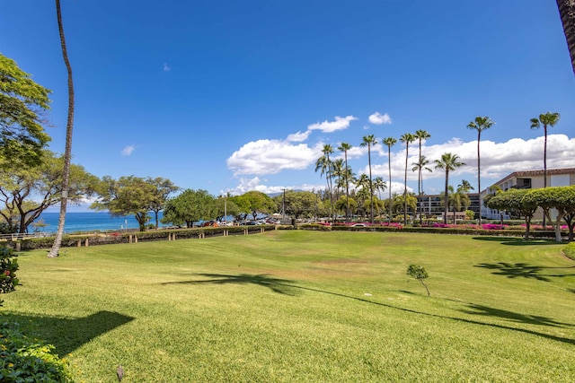 view of property's community featuring a lawn and a water view