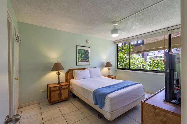 tiled bedroom featuring ceiling fan and a textured ceiling