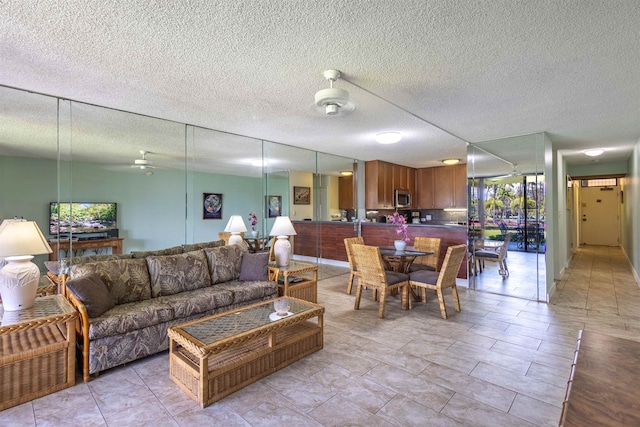 living room with ceiling fan and a textured ceiling