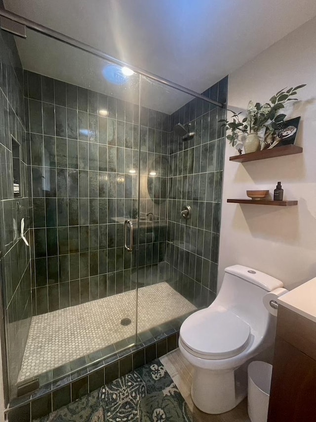 full bath featuring toilet, a shower stall, and vanity