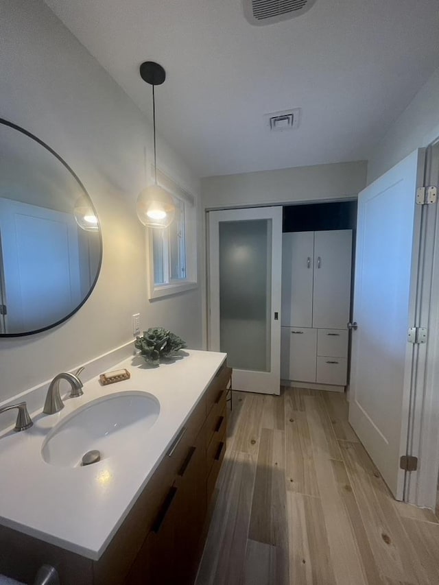 bathroom featuring visible vents, vanity, and wood finished floors