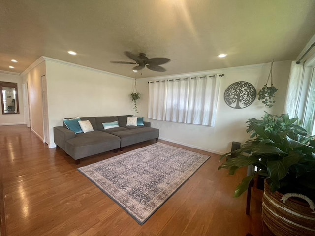 living room featuring wood finished floors, a wealth of natural light, and crown molding