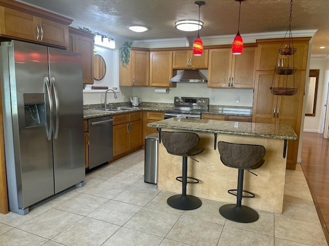 kitchen featuring a center island, pendant lighting, stainless steel appliances, a sink, and under cabinet range hood