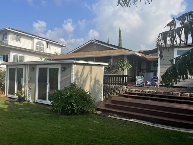 rear view of property featuring a deck and a lawn